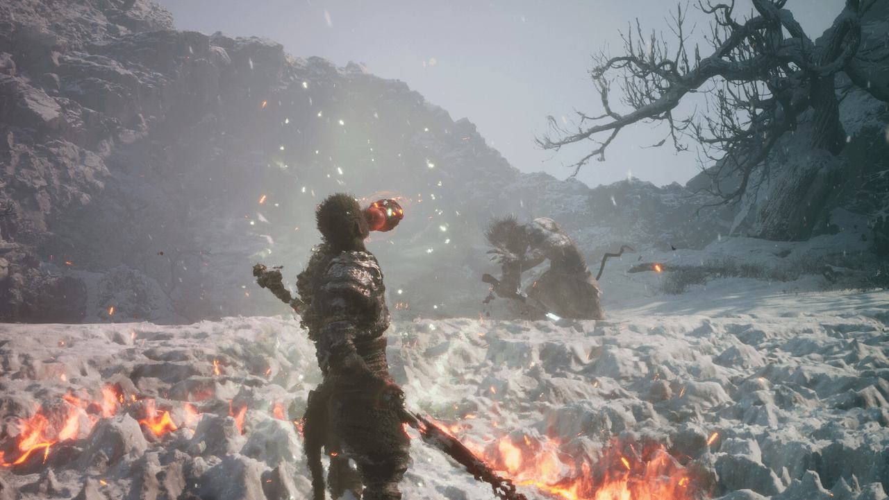 The warrior stands on a snowfield with embers drifting