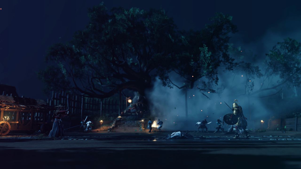 A great tree lit by torches at night